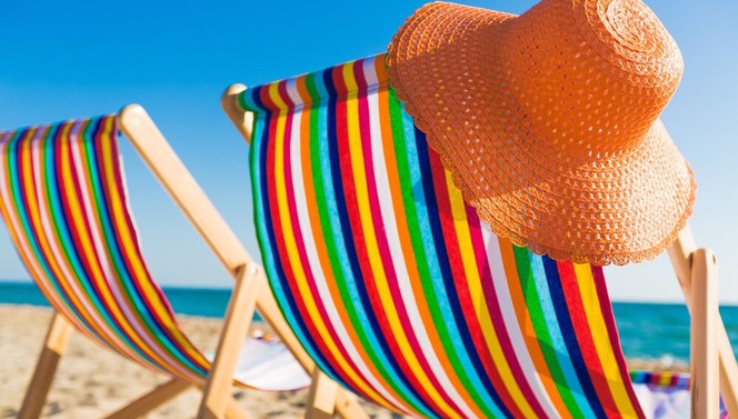  Chapeau de plage orange sur une chaise de plage colorée sur la plage